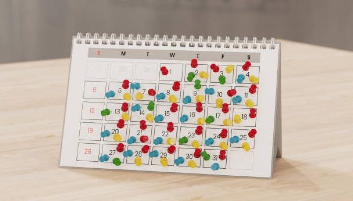 Calendar with lots of push pins, overbooked fully booked schedule concept